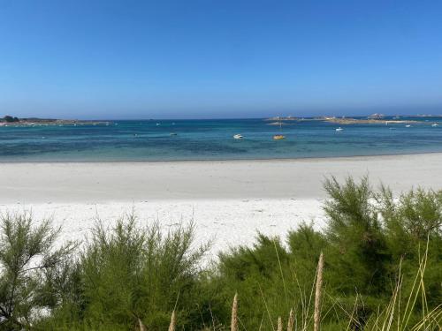 a sandy beach with the ocean in the background at Villa Les Pieds dans l'Eau et sans canicule ! in Santec