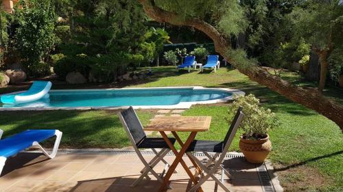 a table and chairs next to a swimming pool at Tamariu Chalet, 3 Bedroom in main house and self contained unit in Tamariu