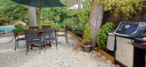 a backyard with a table and chairs and a grill at Tamariu Chalet, 3 Bedroom in main house and self contained unit in Tamariu