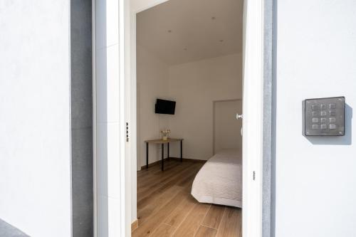 a door leading to a bedroom with a bed at MARAF Rooms in Torre Annunziata