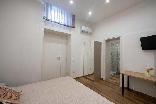 a bedroom with a bed and a tv on a wall at MARAF Rooms in Torre Annunziata