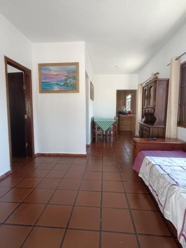 a room with two beds and a table in it at Casa em Ubatuba 1 km do aquário in Ubatuba