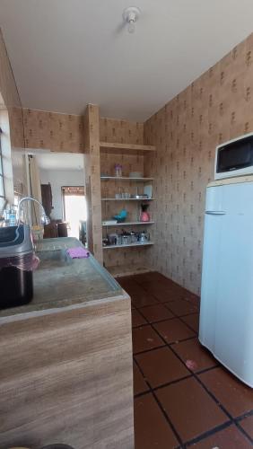 a kitchen with a counter and a refrigerator at Casa em Ubatuba 1 km do aquário in Ubatuba