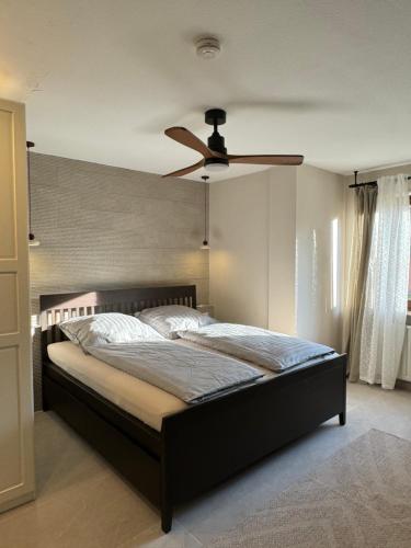 Un dormitorio con una cama con ventilador de techo. en L&K Apartment, en Metzingen