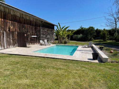 - une piscine dans une cour à côté d'un bâtiment dans l'établissement La Tour du Sorbey - Gîte Nature Familial - Piscine - 3 à 6 Pax, à Monségur