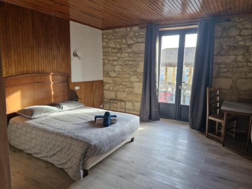 a bedroom with a large bed and a large window at Eden Auberge in Villefranche-du-Périgord