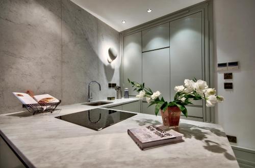 a bathroom with a sink and a vase of flowers on a counter at 10 Strait Street Apartments in Valletta