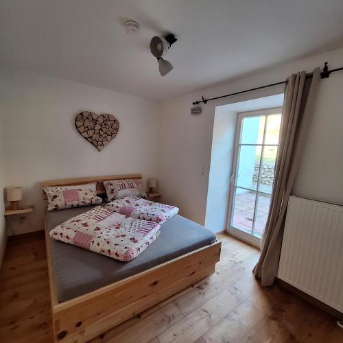 a bedroom with a bed and a large window at Ferienwohnung Gamsblick in Ettal