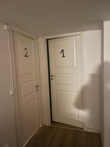 two doors with numbers on them in a room at Kinnarps vandrarhem in Falköping