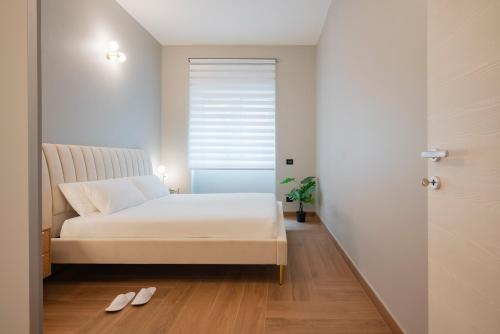 a bedroom with a bed and two slippers on the floor at Visconti Suites - Luca Stay in Milan