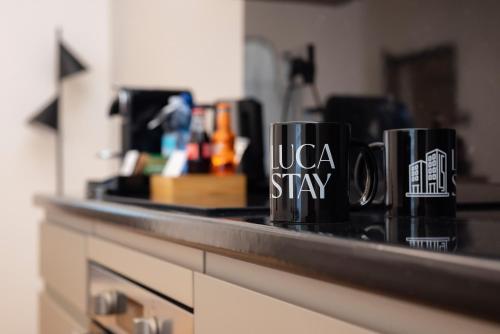 two coffee mugs sitting on a counter in a kitchen at Visconti Suites - Luca Stay in Milan