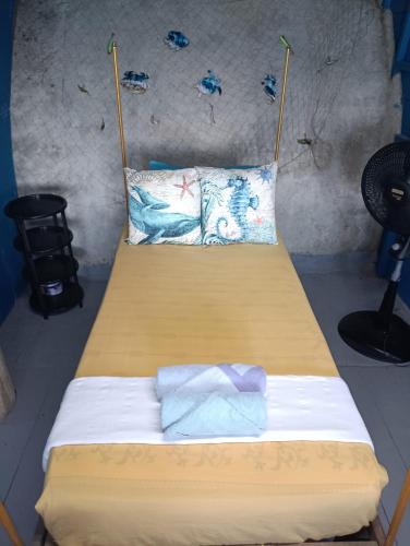 a bed with two pillows on it in a room at Ecolodge el Arca Bahia Solano in Bahía Solano