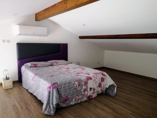 une chambre avec un grand lit dans un grenier dans l'établissement Chambre Familiale, à Saint-Justin