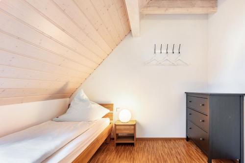 a small bedroom with a bed and a dresser at Winzercafé Neipperg in Brackenheim