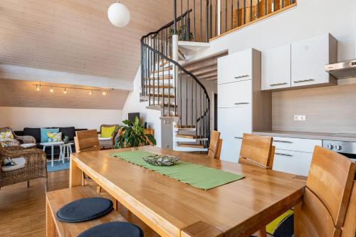 a dining room and living room with a wooden table at Winzercafé Neipperg in Brackenheim