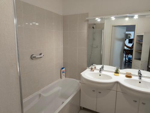 une salle de bain avec une baignoire, un lavabo et une douche dans l'établissement Le spot, à Biscarrosse