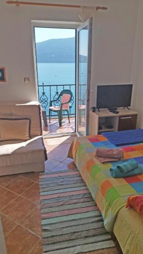 a room with two beds and a view of the ocean at Rooms Beba in Herceg-Novi