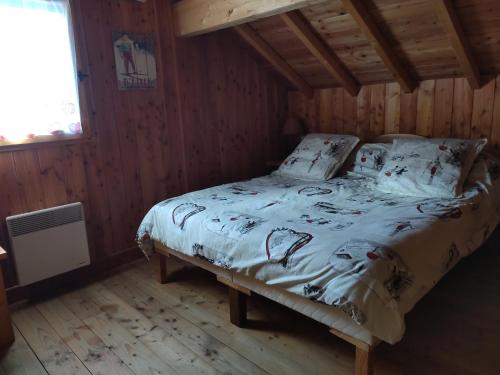 a bedroom with a bed in a wooden room at CHALET MONTAGNE CLASSÉ 3 ETOILES ALPES QUEYRAs in Guillestre