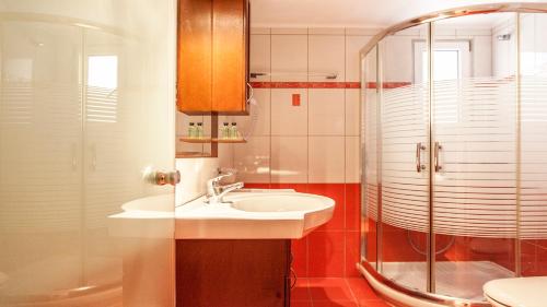 een badkamer met een wastafel en een douche bij Pirofani in Lefkada