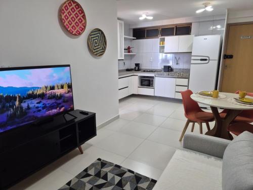 a kitchen and living room with a tv and a table at Vista para o Mar - 05 modelos de Apt - Quarto com Ar - Opção de Café da Manhã in Recife