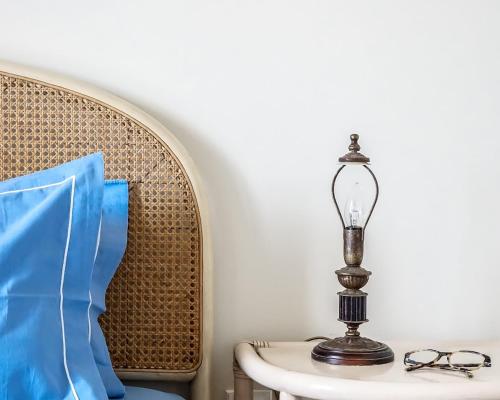 a lamp sitting on a table next to a chair at Carpos Villa in Aegina Town
