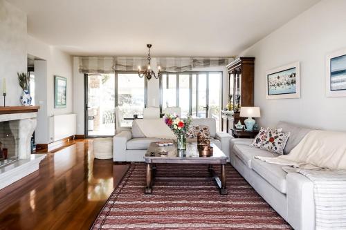 a living room with a white couch and a table at Carpos Villa in Aegina Town