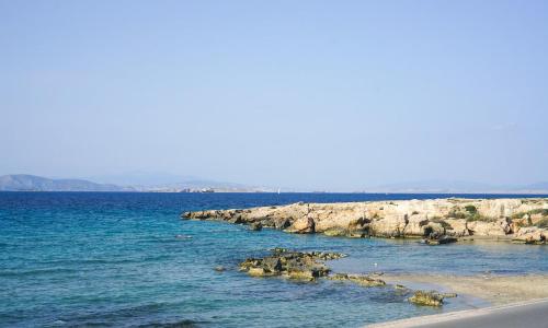 a group of rocks in the water on a beach at Carpos Villa in Aegina Town