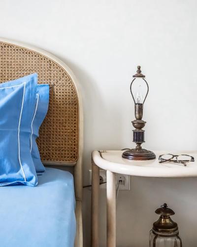 a table with a lamp on it next to a chair at Carpos Villa in Aegina Town