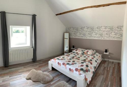 a bedroom with a bed and a window at Le Petit Moineau in Arthon
