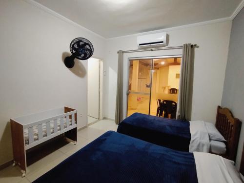 a bedroom with two beds and a sliding glass door at Casa de Maria in Aparecida