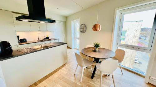 une cuisine et une salle à manger avec une table et des chaises dans l'établissement Penthouse Apartment, à Kristiansand