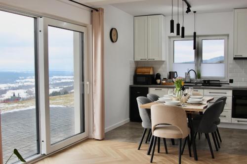 a kitchen and dining room with a table and chairs at Domek Na Sapisku in Szlembark