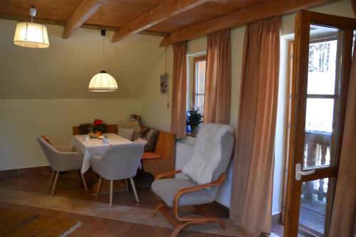 a dining room with a table and chairs and a window at Alm-House HOLLMANN in Železná Ruda