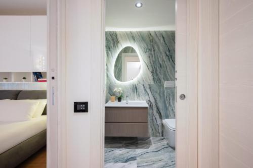 a bathroom with a bed and a sink and a mirror at Visconti Suites - Luca Stay in Milan