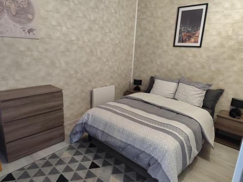 une chambre avec un lit et un mur dans l'établissement L'Appart - Les charmes, à Montceau-les-Mines