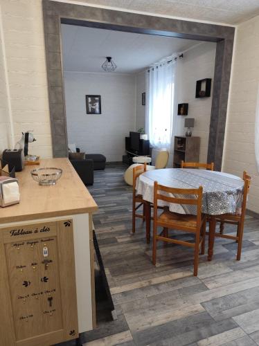 une cuisine et un salon avec une table et des chaises dans l'établissement L'Appart - Les charmes, à Montceau-les-Mines