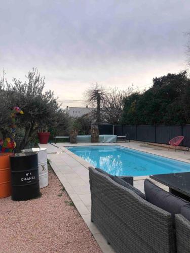 - une piscine avec 2 chaises à côté dans l'établissement La Ciotat T2 dans villa avec piscine, à La Ciotat