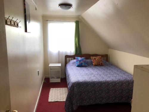 a small bedroom with a bed with a window at Cabañas Diarias in Valdivia