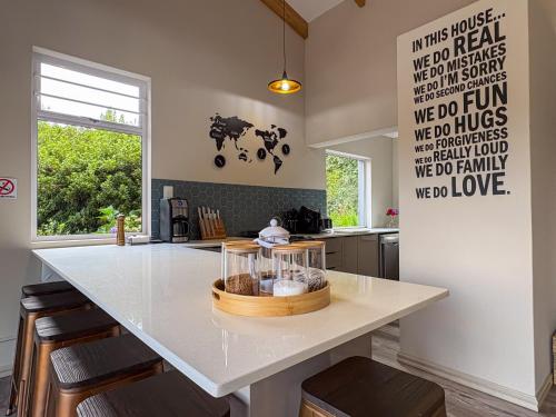 a kitchen with a large white island with stools at The Gate House in Hogsback