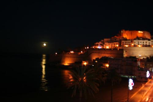 a city lit up at night with a castle at Hotel Mare Nostrum in Peñíscola
