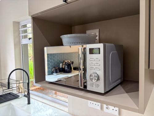 a microwave sitting on a shelf in a kitchen at The Gate House in Hogsback