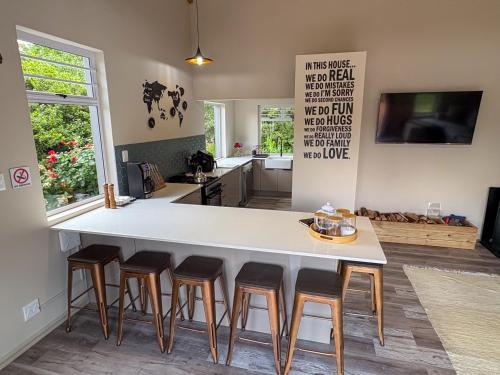 a kitchen with a large white island with bar stools at The Gate House in Hogsback