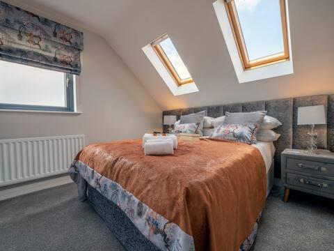 a bedroom with a large bed with two windows at Belfast city stylish spacious apartment great location free parking in Belfast