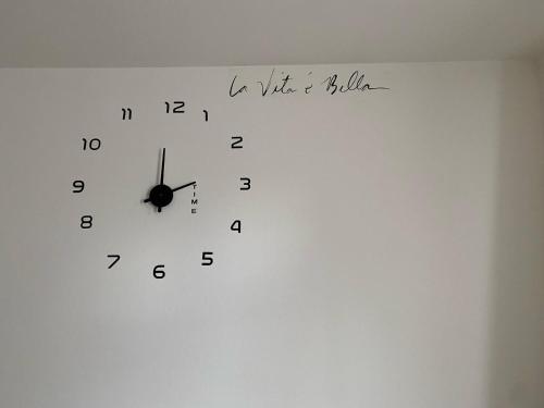 a clock on a wall with writing on it at B&B il Castelletto Siena in Montaperti
