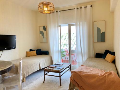a living room with two beds and a table at Apartamento a 400 metros da praia Santa Cruz in Santa Cruz