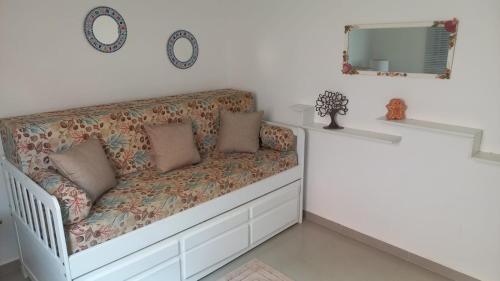 a room with a couch and a mirror at Apartamento com Suíte em Bertioga Indaiá 150 metros da Praia in Bertioga