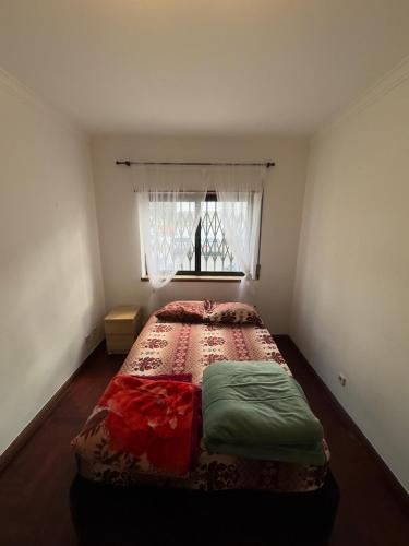 a bed in a bedroom with a window at Destination Caparide in São Domingos de Rana