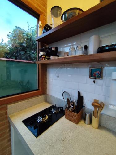 a small kitchen with a stove and a window at Loft BeiraMar 2 in Serra