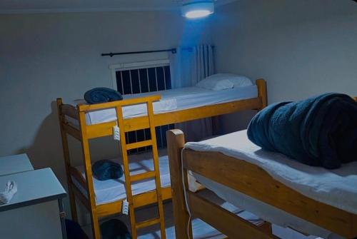 a dorm room with two bunk beds and a desk at Le house hostel in Sao Paulo