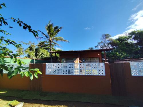 a fence in front of a house with a palm tree at Loft BeiraMar 2 in Serra